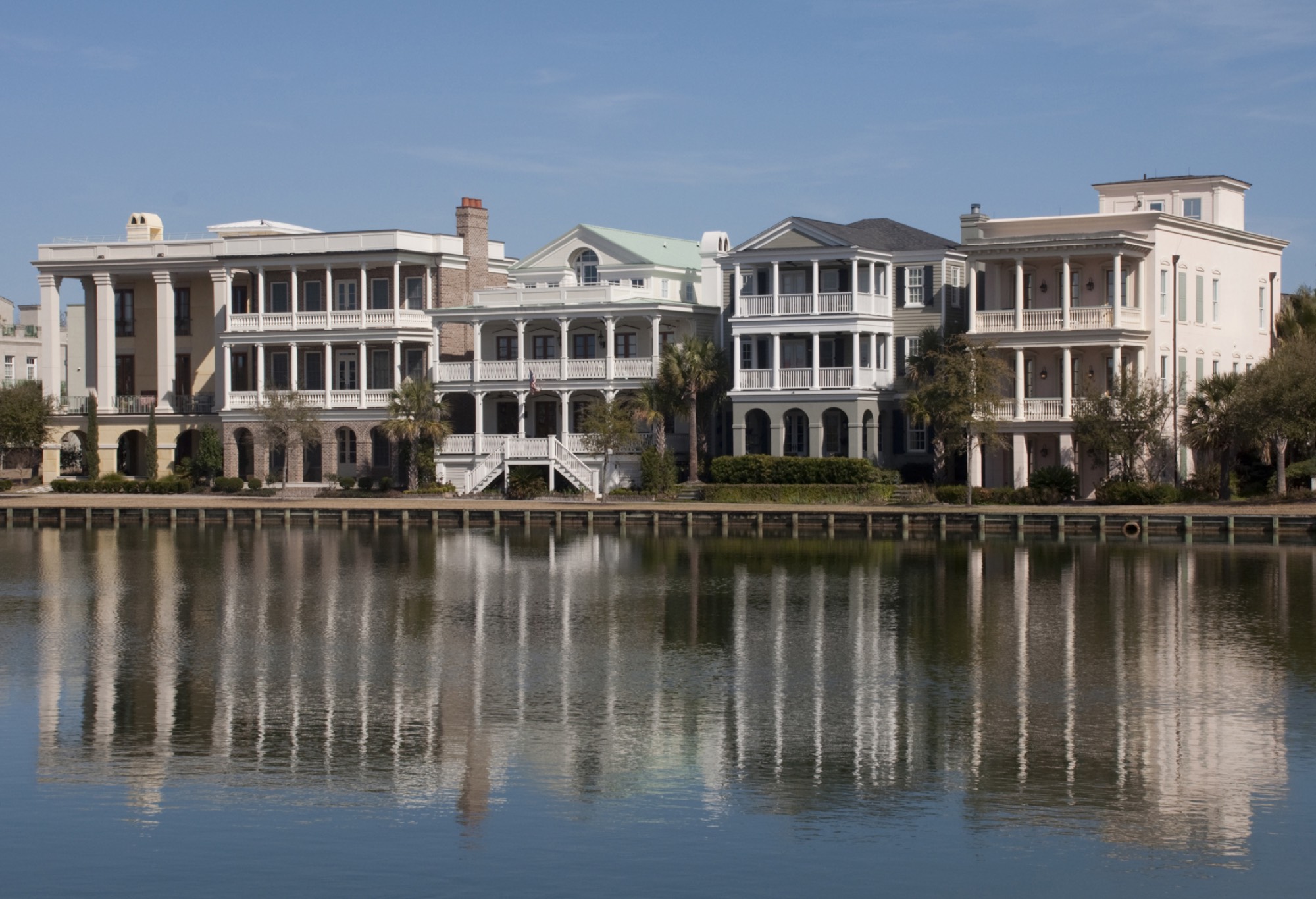 Lowcountry homes with deep double porches and palmettos reflected in still water at I'On, Mount Pleasant