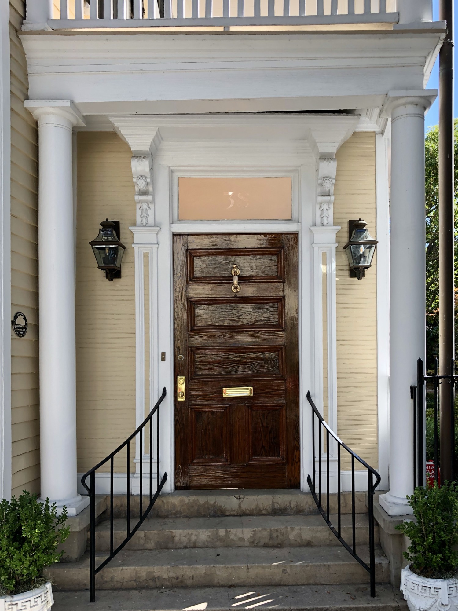 A front door flanked by two hanging lanterns on a Lowcountry home